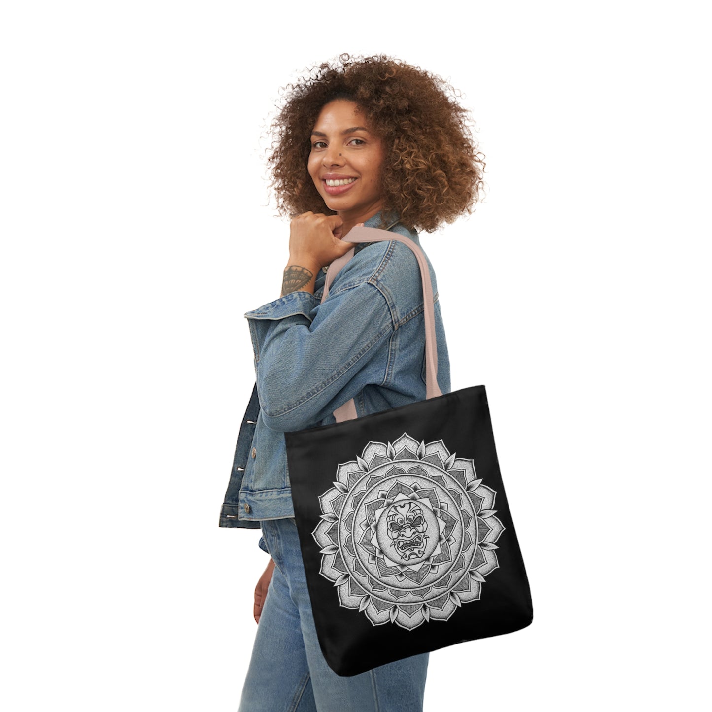 smiling woman holding black mandalarian brand tote bag with light pink handle and samurai mask design print on both sides