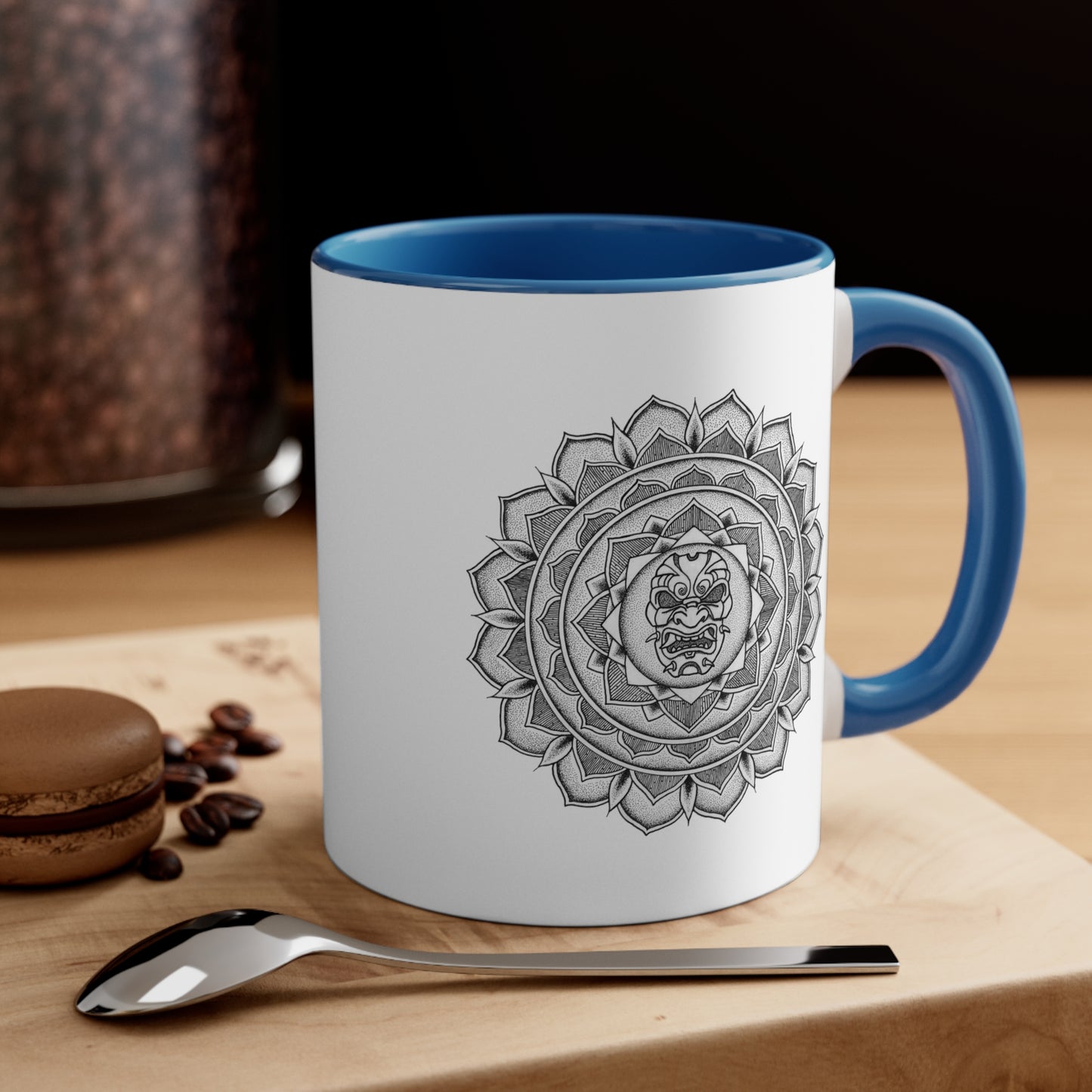 a two toned white and blue 11oz coffee mug on a table with a samurai mask mandala design