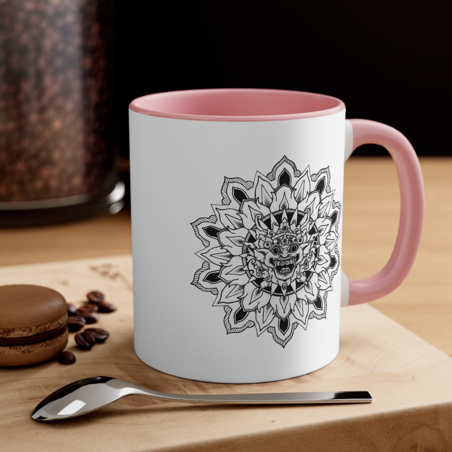 a two-toned white and pink 11oz coffee mug with bhoma bali god mandala design on both sides