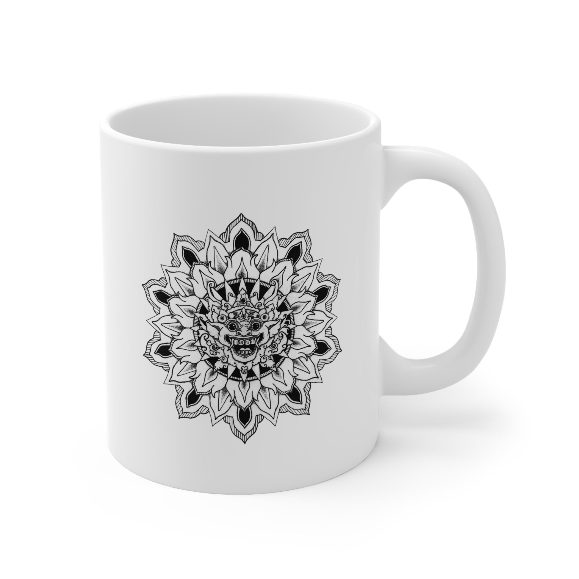 a white 11oz coffee mug with black bhoma bali god mandala design