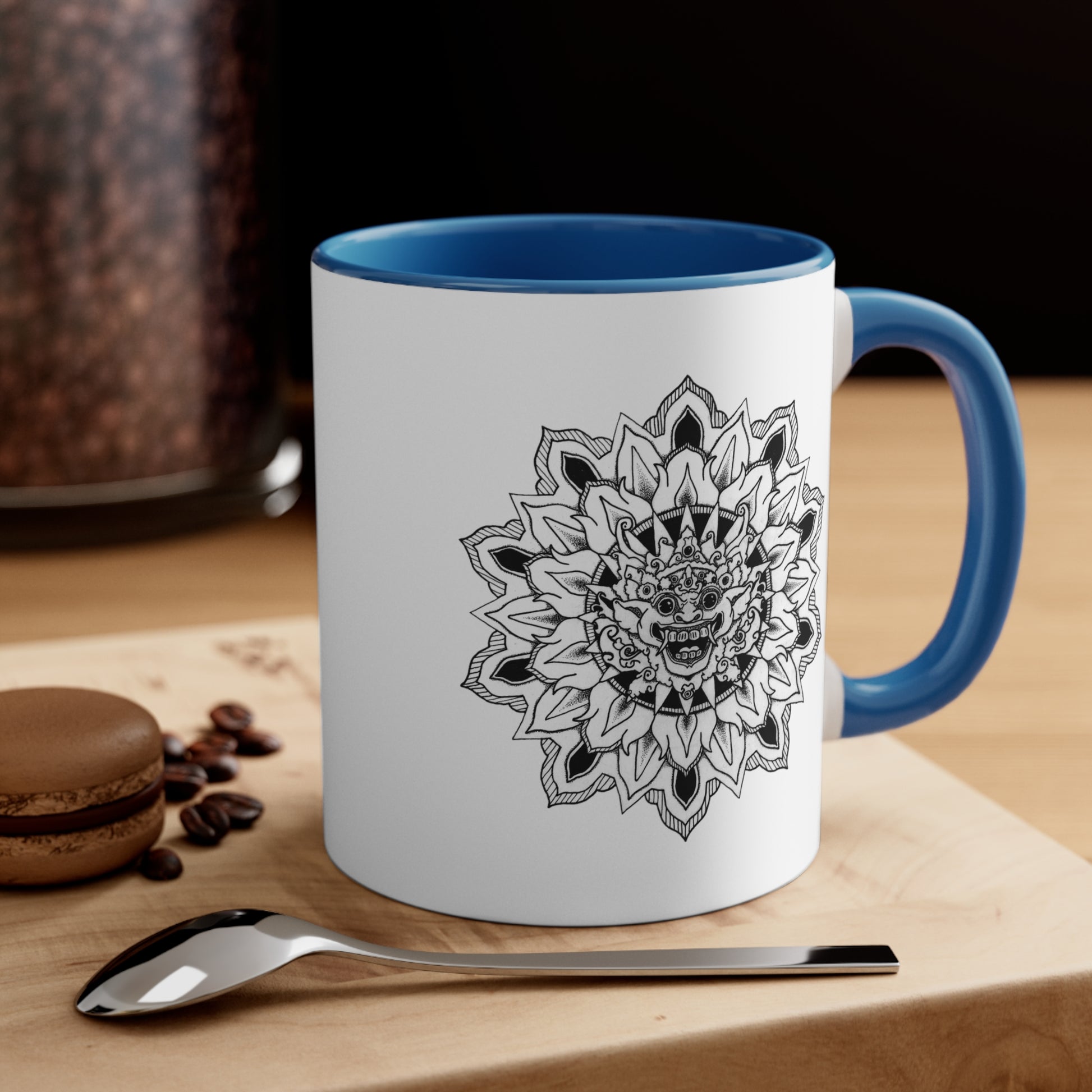 a two-toned white and blue 11oz coffee mug with bhoma bali god mandala design on both sides