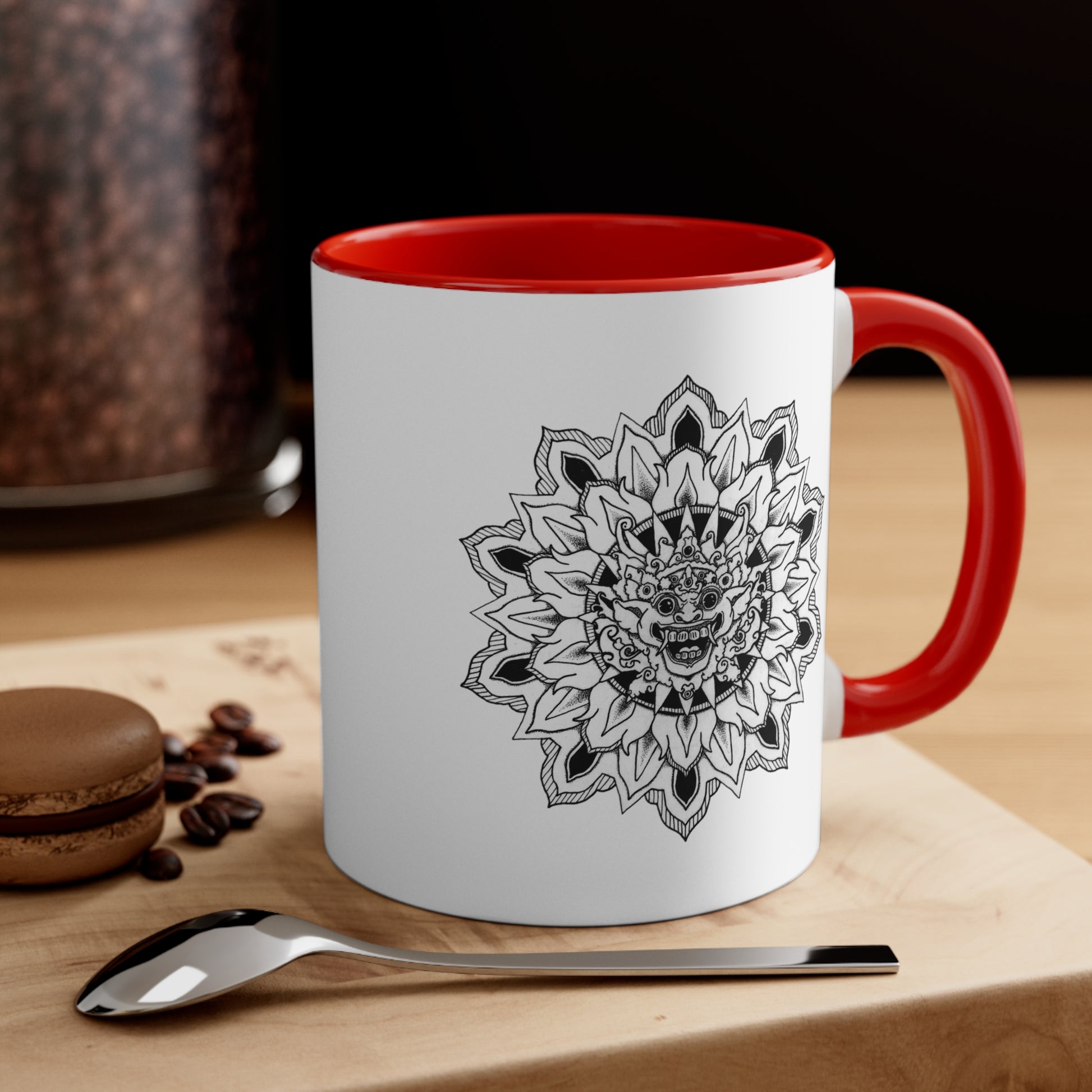 a two-toned white and red 11oz coffee mug with bhoma bali god mandala design on both sides