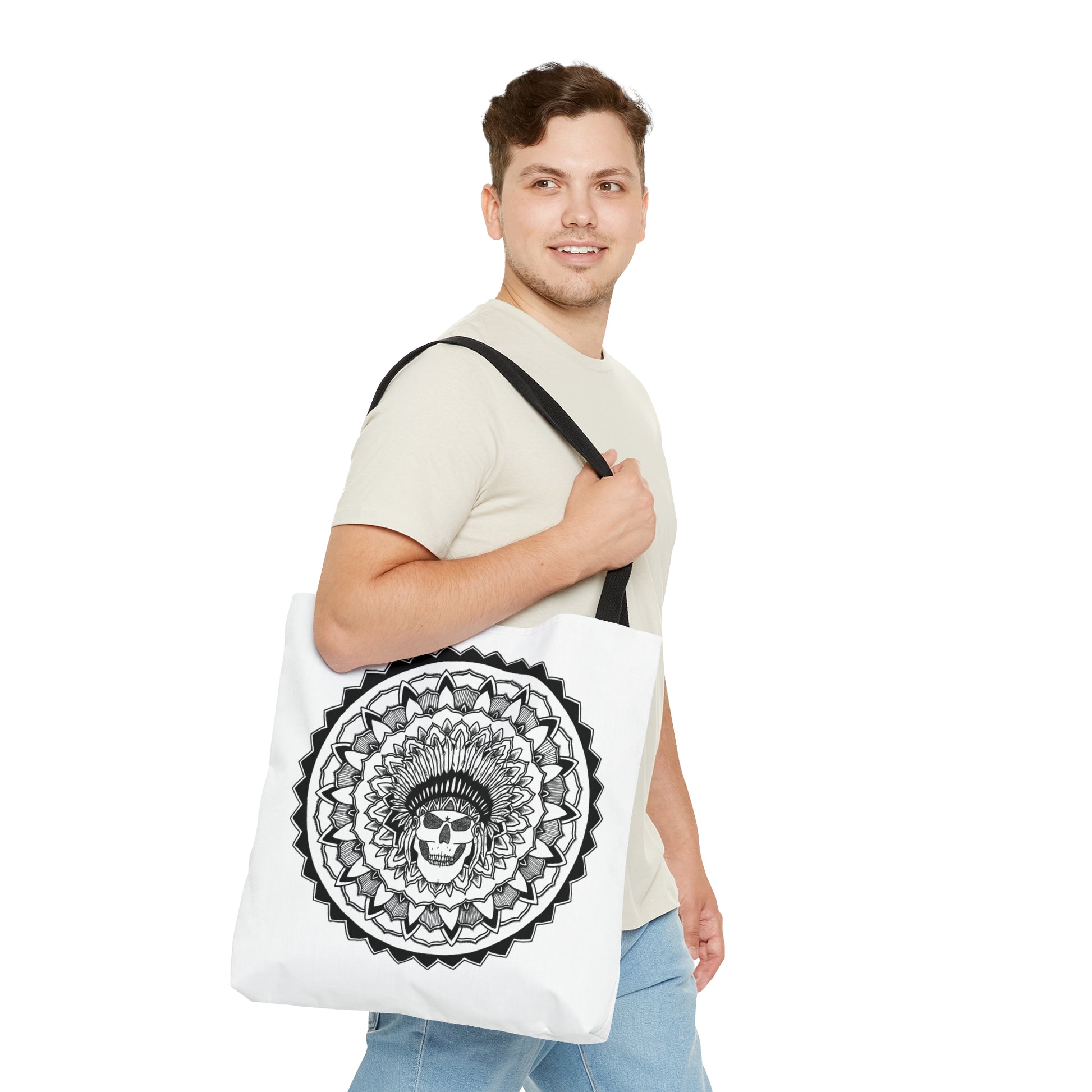 image of a man holding a white mandalarian brand tote bag with black handle and black and white chieftain skull tattoo mandala design print on both sides