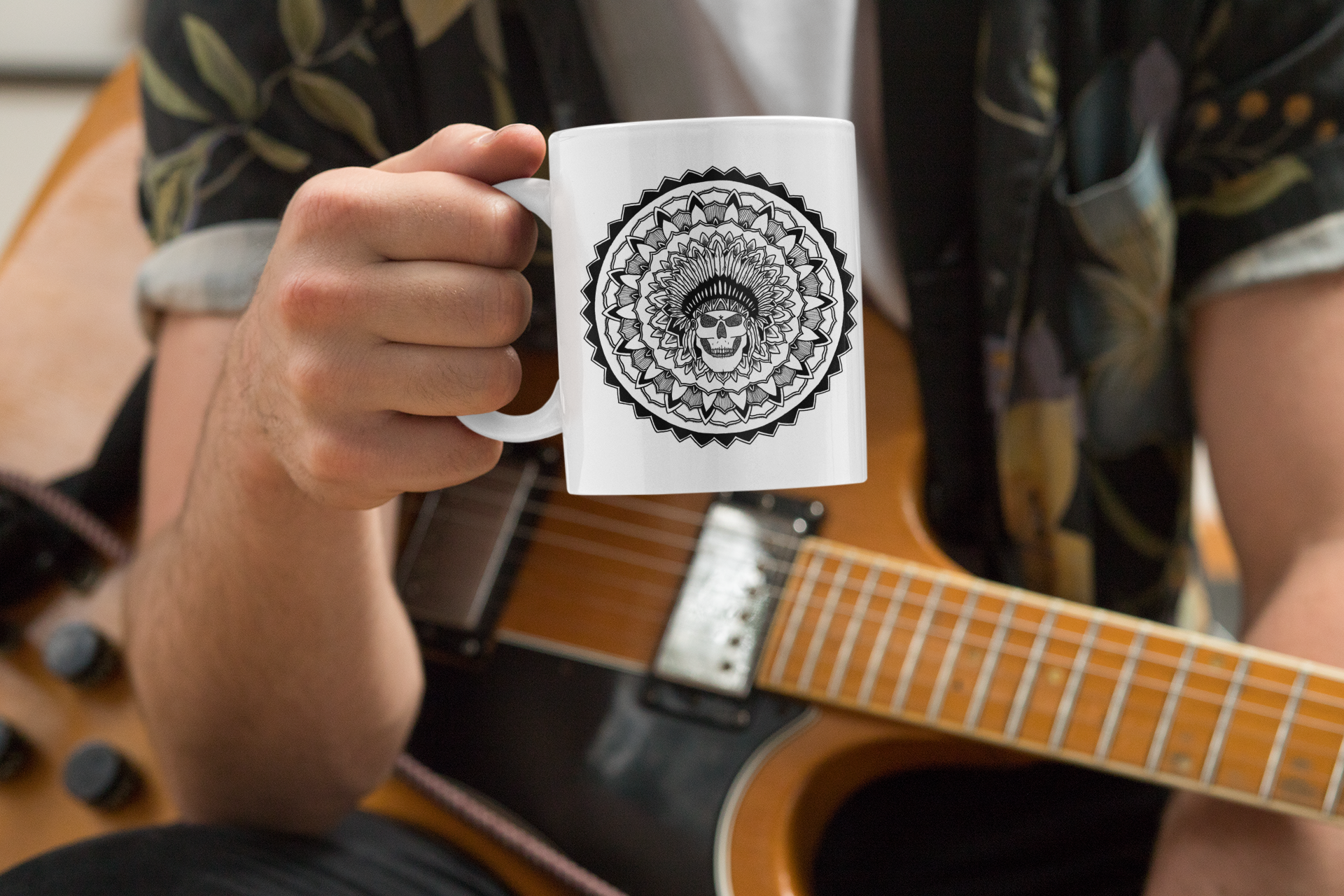 an electric guitar musician holding a white 11oz coffee mug with a chieftain skull mandala design on it