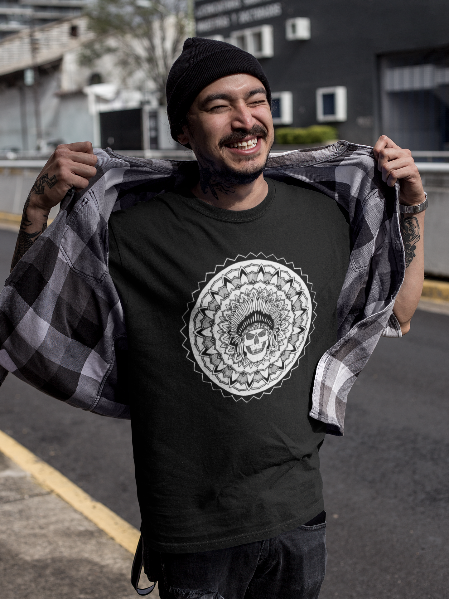 a smiling tattooed man wearing a mandalarian black t-shirt with a chieftain mandala design in the streets